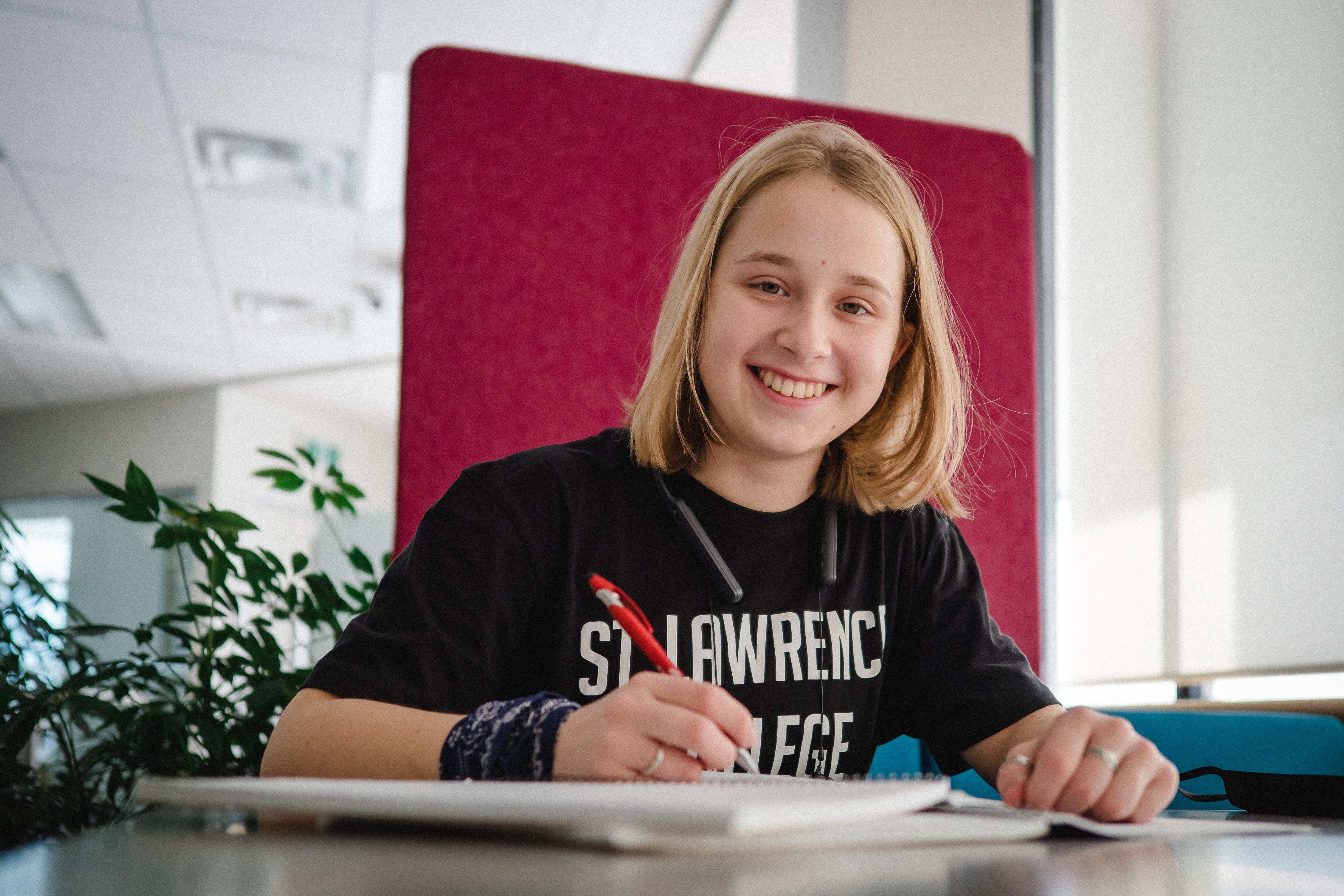 student smiling while writing